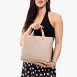Oatmilk Classic | Model holding midsize crossbody tote with handles and a pocket