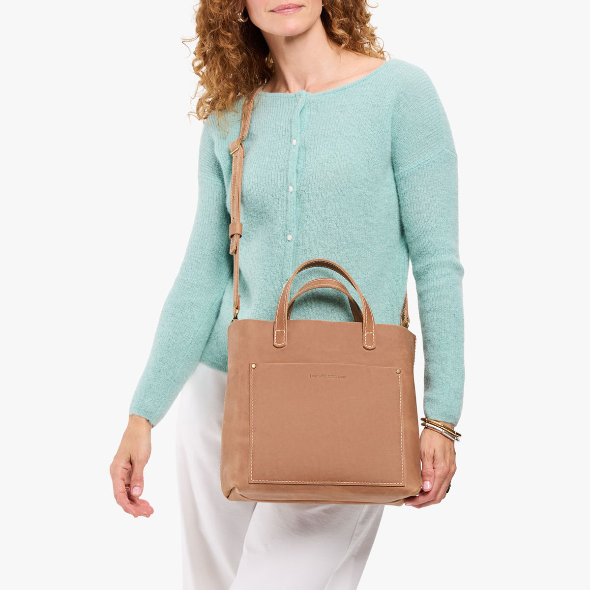 Rodeo | Model wearing a midsize crossbody tote with handles and a front pocket