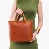 Sienna Zipper | Model holding midsize crossbody tote with handles and a pocket