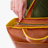 Sienna Zipper | Model holding midsize crossbody tote with handles and a pocket