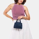 Deep Water Mini | Model carrying small leather tote bag with handles, adjustable crossbody strap, and one back pocket