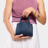 Deep Water Mini | Model holdng small leather tote bag with handles, adjustable crossbody strap, and one back pocket