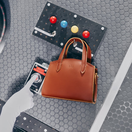 Honey*Mini | Leather tote bag with handles, adjustable crossbody strap, zipper top, and a back pocket