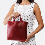 Chili Red Classic | Model holding crossbody tote bag with snap closure and front pocket