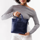 Cobalt Classic | Model holding crossbody tote bag with snap closure and front pocket