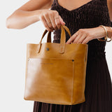 Mango Classic | Model holding crossbody tote bag with snap closure and front pocket