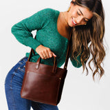 Cognac Zipper | Model holding crossbody tote bag with zipper closure and front pocket