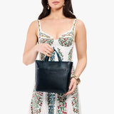 Boreal Zipper | Model holding crossbody tote bag with zipper closure and front pocket