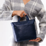 Cobalt Zipper | Model holding crossbody tote bag with zipper closure and front pocket