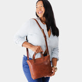 Nutmeg Zipper | Model holding crossbody tote bag with zipper closure and front pocket