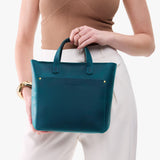 Westward Blue Zipper | Model holding crossbody tote bag with zipper closure and front pocket