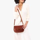 Nutmeg Large | Model wearing a leather Crossbody with a flap and magnetic closure