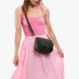 Evergreen Small | Model wearing a petite leather Crossbody with a flap and magnetic closure