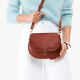 Nutmeg Small | Model wearing a petite leather Crossbody with a flap and magnetic closure