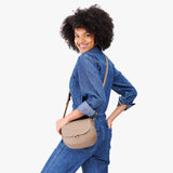 Stone Small | Model wearing a petite leather Crossbody with a flap and magnetic closure