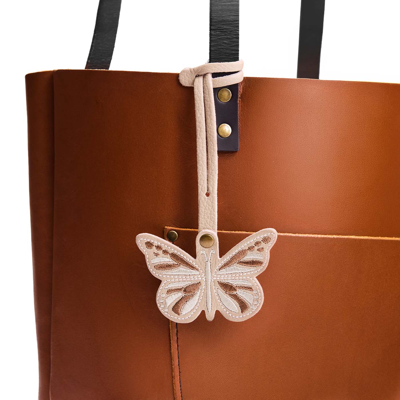 Oatmilk | Embroidered butterfly tassel accessory on a bag