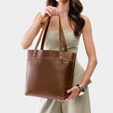 Asheville Medium Classic | Model holding a leather tote bag with riveted straps and exterior key loop