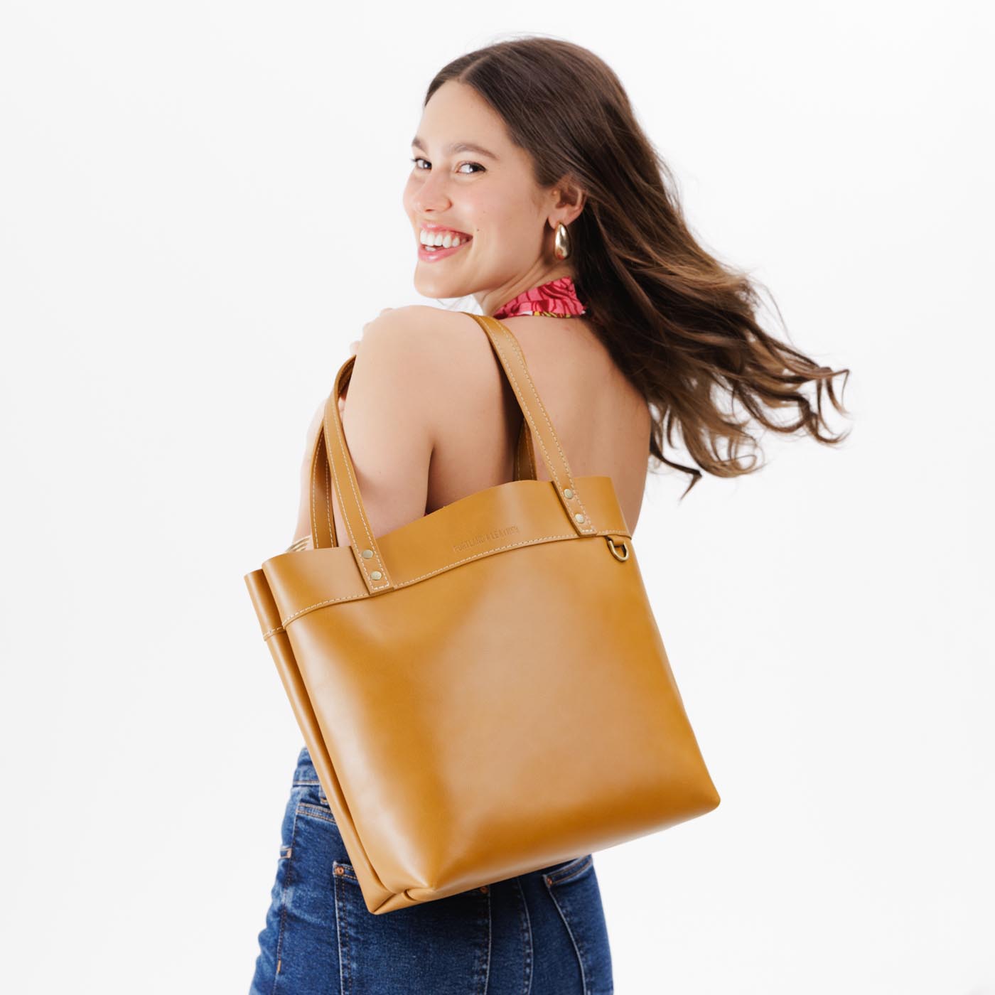 Mango*Medium*Classic | Model wearing leather tote bag with riveted straps and exterior key loop