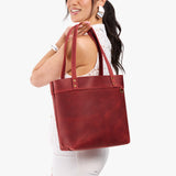 Phoenix Medium Classic | Model wearing leather tote bag with riveted straps and exterior key loop