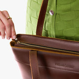 Cognac Medium Zipper | Model wearing leather tote bag with riveted straps and exterior key loop