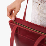 Phoenix Medium Zipper | Model wearing leather tote bag with riveted straps and exterior key loop