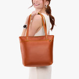 Sienna Medium Zipper | Model wearing leather tote bag with riveted straps and exterior key loop