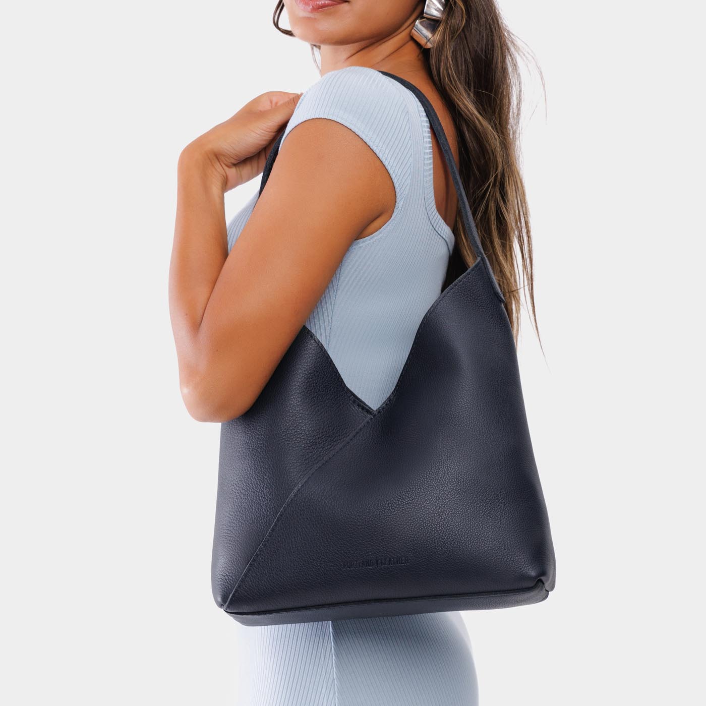 Night Owl*Large | Model wearing mid-size shoulder bag with adjustable strap and magnetic snap closure