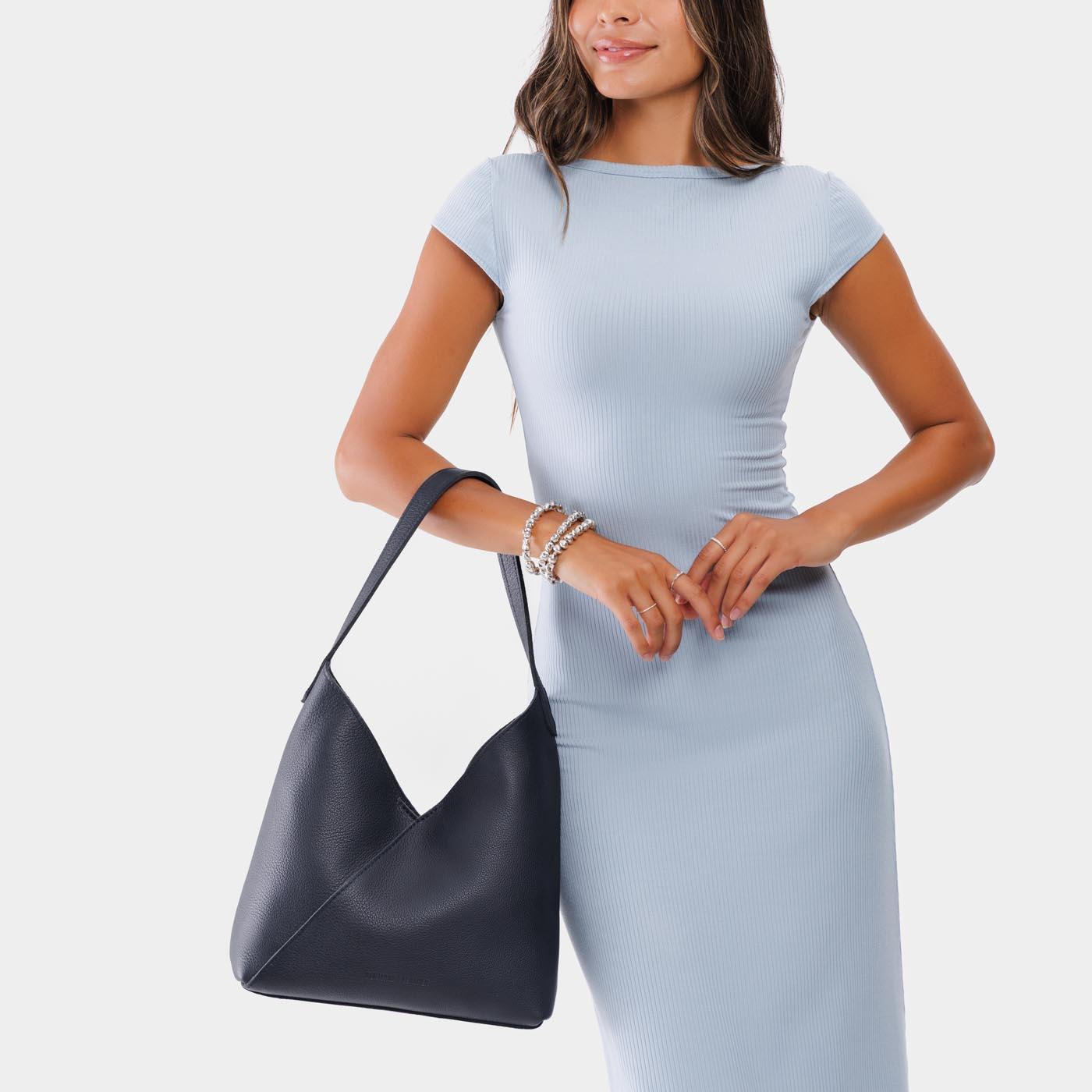 Night Owl*Large | Model wearing mid-size shoulder bag with adjustable strap and magnetic snap closure