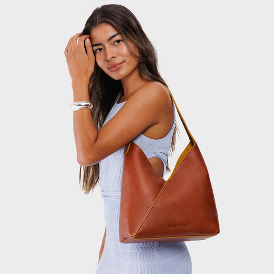 Sienna*Large | Model wearing mid-size shoulder bag with adjustable strap and magnetic snap closure