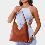 Sienna Large | Model holding mid-size shoulder bag with adjustable strap and magnetic snap closure