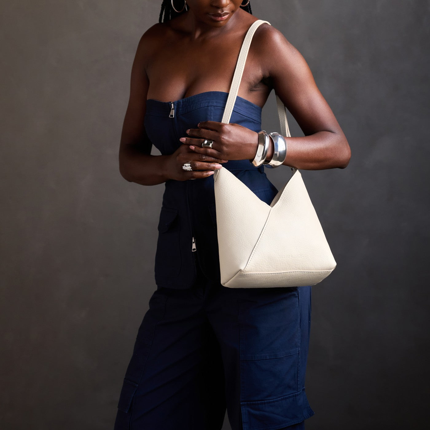 Pebbled Bone*Small | Model carrying petite shoulder bag with adjustable strap and magnetic snap closure