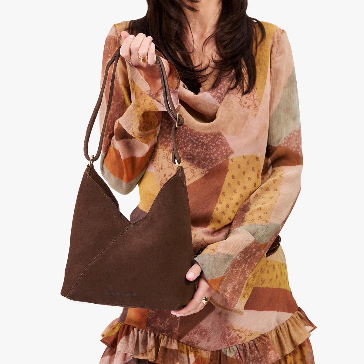 Stagecoach*Small | Model holding petite shoulder bag with adjustable strap and magnetic snap closure