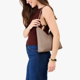 Stone Small | Model wearing petite shoulder bag with adjustable strap and magnetic snap closure