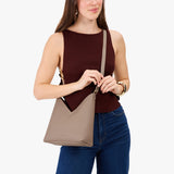Stone Small | Model wearing petite shoulder bag with adjustable strap and magnetic snap closure