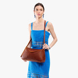 Nutmeg Medium | Model wearing a leather Crossbody with a flap and magnetic closure