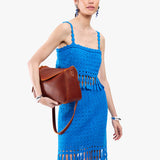 Nutmeg Medium | Model wearing a leather Crossbody with a flap and magnetic closure