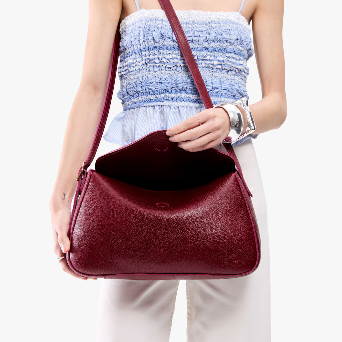 Orchid*Medium | Model wearing a leather Crossbody with a flap and magnetic closure