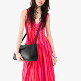 Pebbled--black Medium | Model wearing a leather Crossbody with a flap and magnetic closure