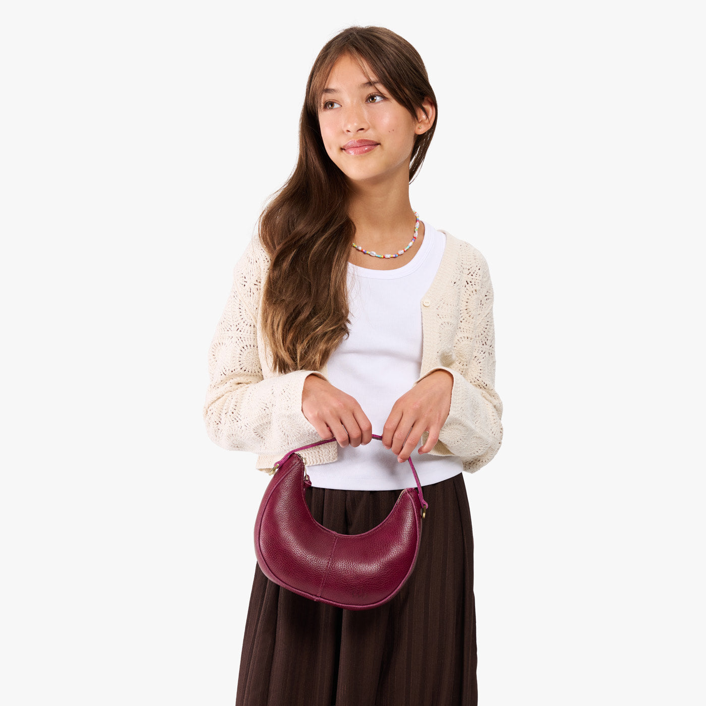 Orchid | Model with a crescent shaped shoulder bag with zipper closure and gold accents