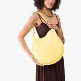 Butter Bliss Large | Model holding round leather purse with adjustable shoulder strap