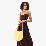 Butter Bliss Large | Model holding round leather purse with adjustable shoulder strap