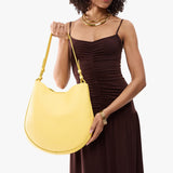 Butter Bliss Large | Model holding round leather purse with adjustable shoulder strap