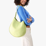 Shadow Lime Large | Model carrying round leather purse with adjustable shoulder strap