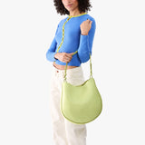 Shadow Lime Large | Model carrying round leather purse with adjustable shoulder strap