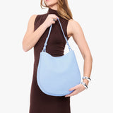 Skyway Large | Model holding round leather purse with adjustable shoulder strap