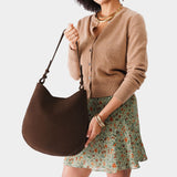Stagecoach Large | Woman wearing rounded shoulder bag with adjustable strap on a white background