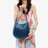Caspian Medium | Model holding round leather purse with adjustable shoulder strap