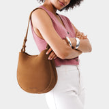 Jackson Medium | Woman wearing rounded shoulder bag with adjustable strap on a white background
