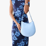 Skyway Medium | Model holding round leather purse with adjustable shoulder strap