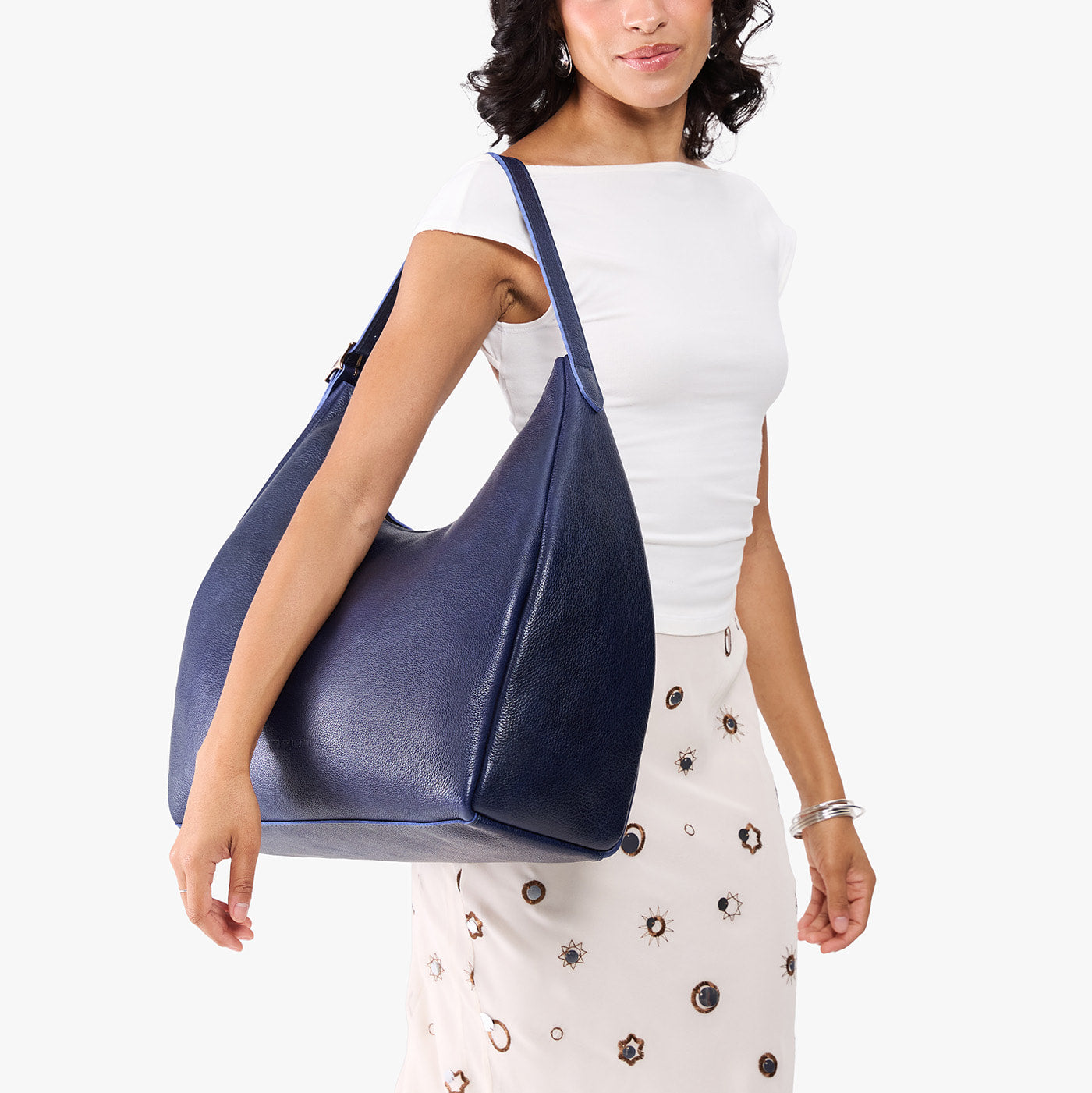 Cobalt*Oversized | Model carrying U-shaped, flat-bottomed leather shoulder bag with adjustable strap